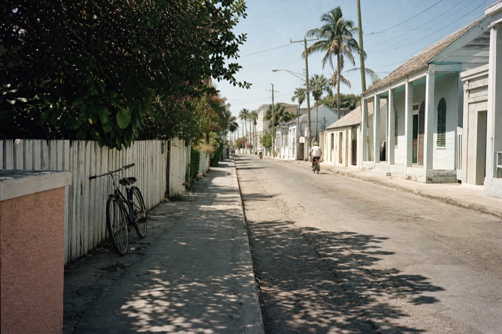 A flat Old Town street in Key West with pastel buildings and palms, no text, no logos, no people