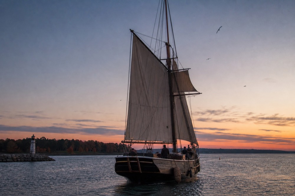A wooden tall ship schooner with sails raised at dusk near Key West, no text, no logos, no people