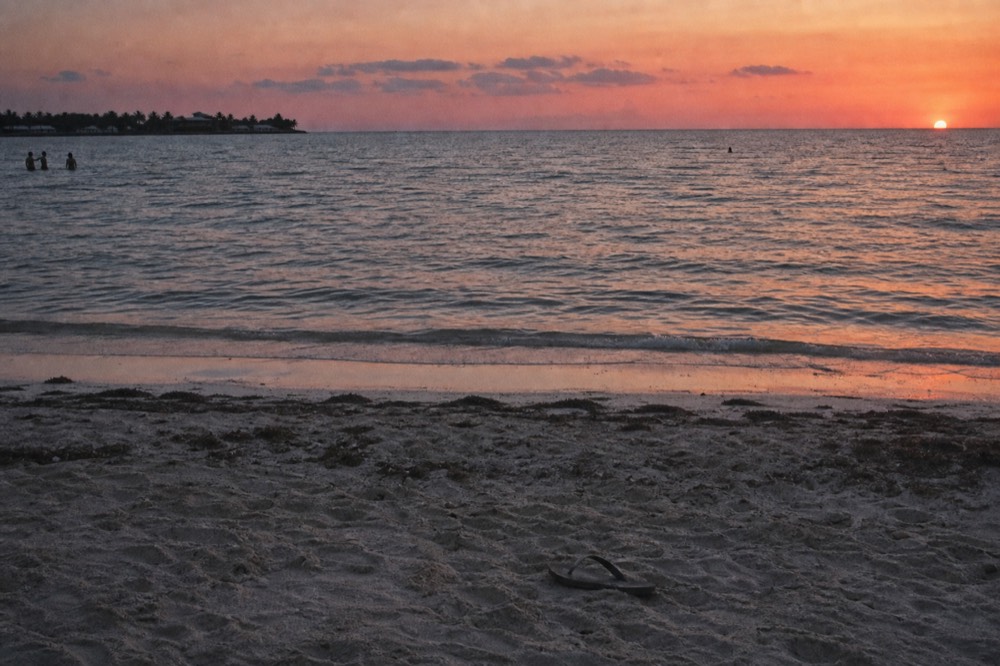The sun sinking into the Gulf of Mexico horizon off Key West with orange and pink sky, no text, no logos, no people.