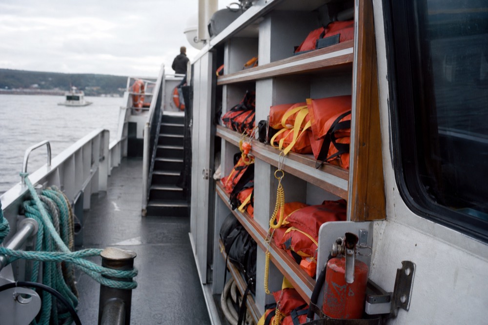 Life vests and safety equipment stowed neatly on a sailing vessel deck, no text, no logos, no people