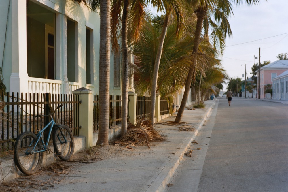 A quiet palm-lined Key West street in warm evening light with pastel buildings, no text, no logos, no people