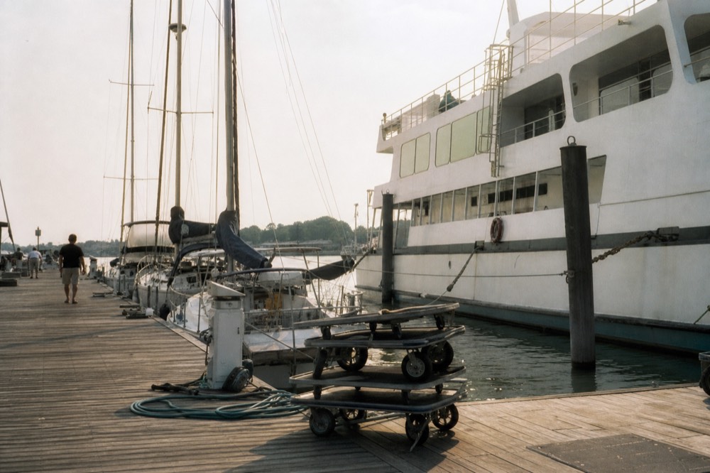 A ferry and sailboats at the Key West Historic Seaport marina in late afternoon light, no text, no logos, no people.