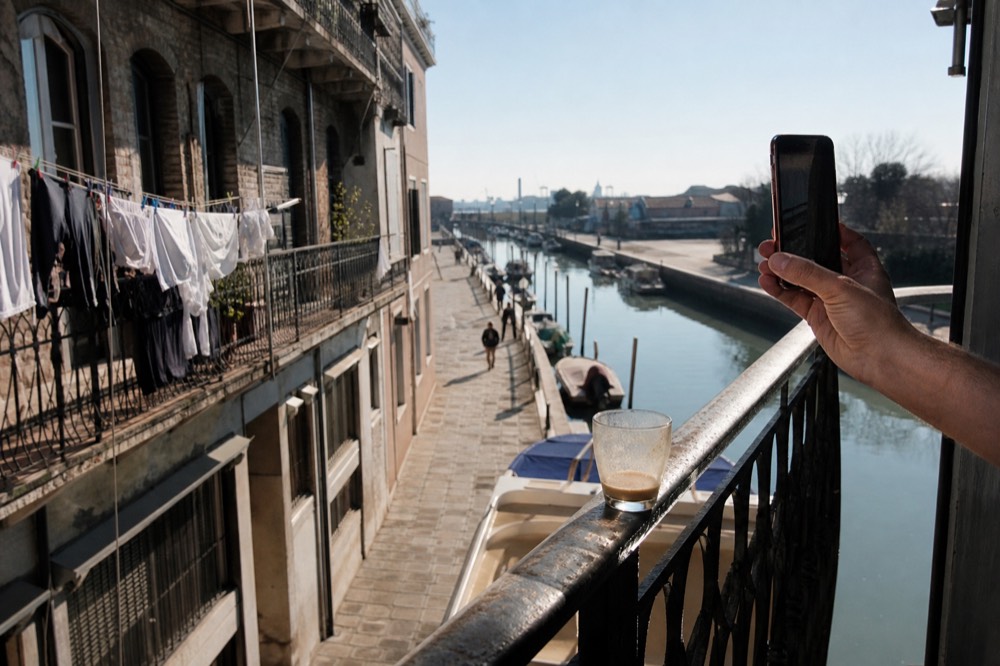 A smartphone showing a booking screen on a sunny Key West balcony overlooking boats, no text, no logos, no people