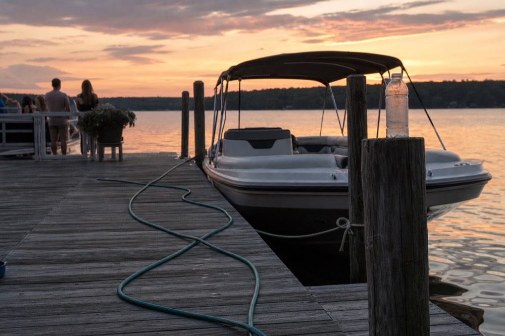 A resort dock at dusk with a boat waiting at the slip, no text, no logos, no people.